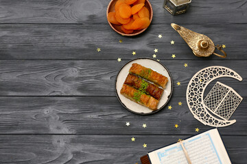 Baklava, Koran, Aladdin lamp and dried apricots on wooden background. Ramadan celebration