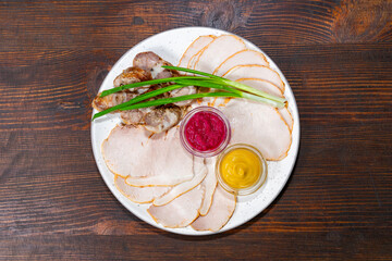 Delicious assorted cold cuts with dipping sauces and green onions