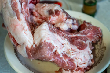 Fresh cuts of pork on a plate in a kitchen setting