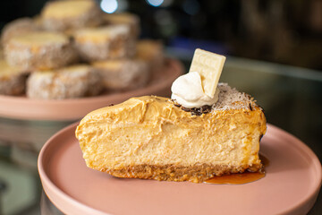 Close-up of a vegan caramel cheesecake slice with whipped cream and white chocolate
