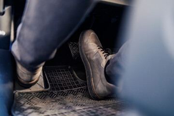 Close up of feet pressing break in car.