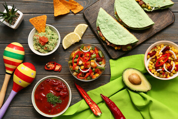 Traditional Mexican food and maracas on black wooden background. Cinco de Mayo (Fifth of May) celebration