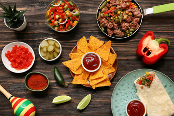 Traditional Mexican food and maraca on black wooden background. Cinco de Mayo (Fifth of May) celebration