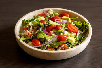 fresh delicious spring salad with lettuce, tomato, cucumber, and feta cheese close-up