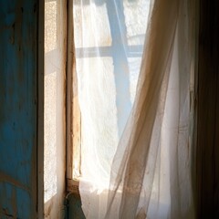 Sunlit, tattered curtains in a weathered window