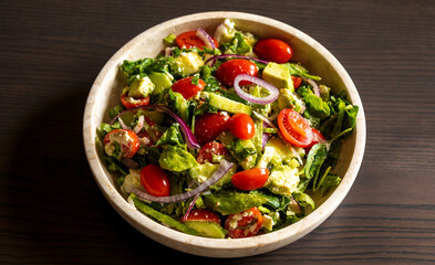 fresh delicious spring salad with lettuce, tomato, cucumber, and feta cheese close-up
