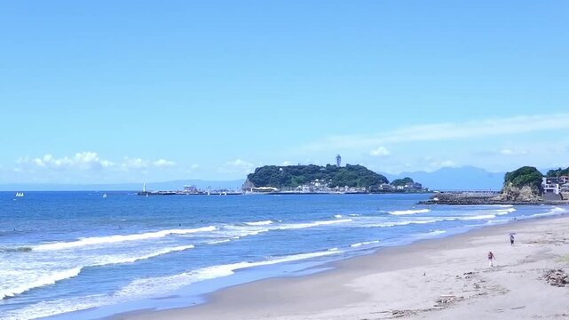 多くの観光客が訪れる夏真っ盛りの湘南・鎌倉の海と、美しい江ノ島の風景の動画素材
