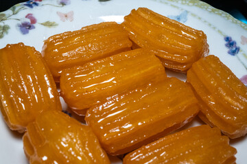 Turkish street dessert tulumba dessert on white plate in close-up