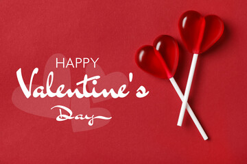 Happy Valentine's day card. Heart-shaped lollipops on red background, top view