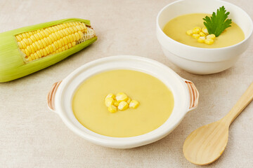 Creamy corn soup in ceramic bowl on the table. Vegetarian food
