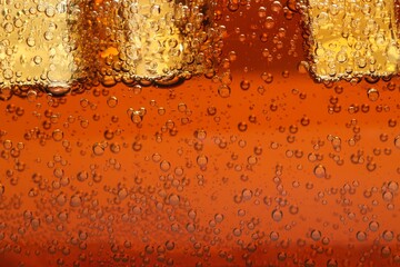 Refreshing soda water with ice cubes as background, closeup