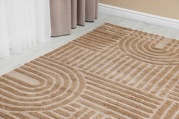 Stylish soft rug with pattern on floor indoors, closeup