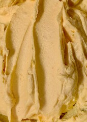 A close-up view reveals a creamy yellow gelato, highlighting its rich texture and smooth, inviting surface. This delicious treat looks freshly made and ready to savor