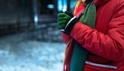 Young Man Shivering at a Bus Stop While Waiting for Public Transport in Cold Weather.