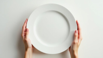Hands holding an empty white plate against a plain background