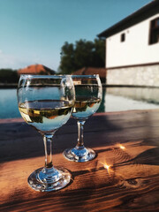 A pair of wine glasses by the pool, relaxing Serbian countryside vacation