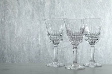 Three empty clean glasses on grey table. Space for