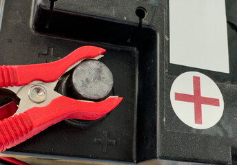 A battery terminal with a red clamp connected to the positive contact