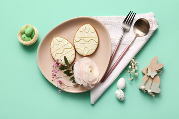 Beautiful table setting with sweet cookies, Easter eggs and gypsophila flowers on turquoise...