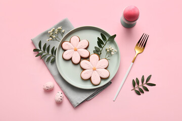 Beautiful table setting with sweet cookies, Easter eggs and gypsophila flowers on pink background