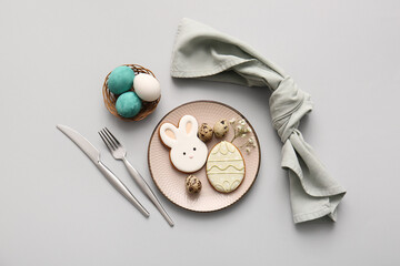 Beautiful table setting with sweet cookies, Easter eggs and gypsophila flowers on grey background