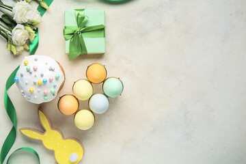 Composition with gift box, flowers, Easter eggs and cake on beige grunge background