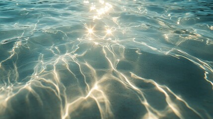 Fototapeta premium Smooth rippling patterns in transparent seawater, sunlight casting dreamy highlights over the delicate waves