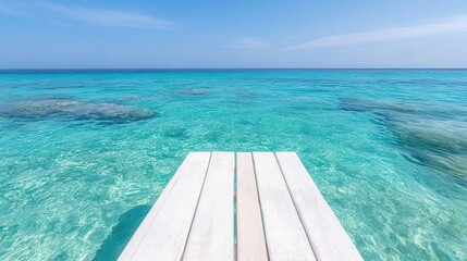 Fototapeta premium Azure blue ocean with a wooden dock leading into the distance, inviting visitors to dive into the crystal-clear water.