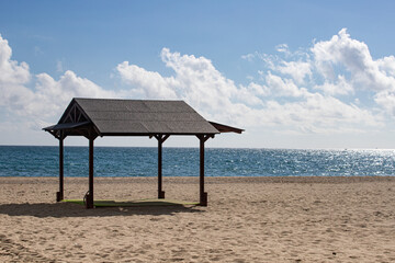 Paisaje de playa con cabaña tranquila para descansar y un mar azul que se pierde en el horizonte