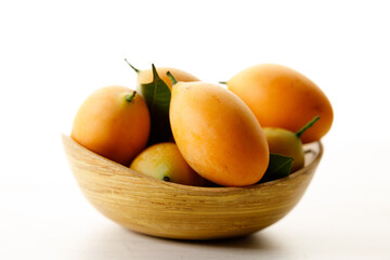 Plum Mango or Marian Plum fruit in wooden tray.