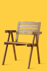 Modern wooden chair on yellow background