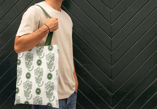 Anonymous Man Holds Tote Bag Against Textured Wall Backdrop. Change strap's color and/or totebag's color to your choice In addition to being able to introduce your own design