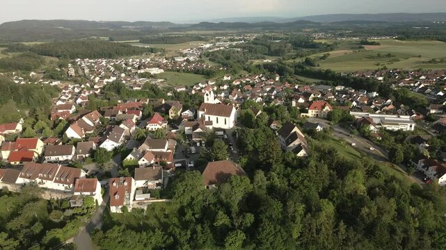 Drone footage circling around the historic hilltop town of Aach in Baden-W&uuml;rttemberg, moving towards the right side while capturing the village and surrounding landscape.