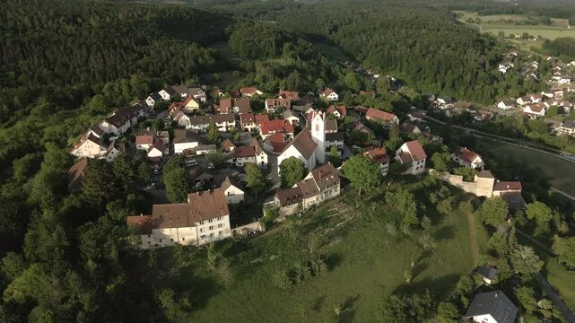Drone footage flying forward towards the historic church tower in Aach, Baden-W&uuml;rttemberg, showcasing the old town and surrounding village with a scenic backdrop.