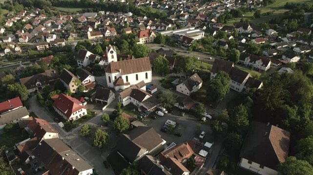 Drone footage moving out to reveal Aach's historic old town with a focus on the church tower, showcasing the surrounding village and scenic landscape.
