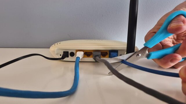 Scissors cut the internet cable connected to the WAN portal of a router
