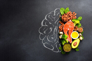 A picture of the brain drawn in chalk with various food products: fish, meat, nuts, vegetables and...