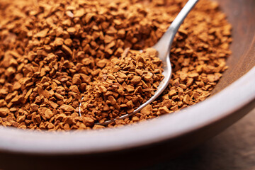 Metal spoon of instant coffee granules. Roasted organic soluble ingredient of aromatic traditional drink in wooden bowl. Energy boost and refreshment concept. Macro shot