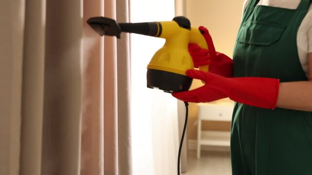 Professional janitor cleaning window curtain with vapor steam system at home, closeup