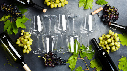 Wine glasses on table with grapes and grape leaves. On a gray stone background. Top view.