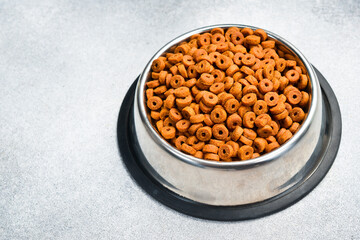 A bowl of dry dog ​​or cat food pellets. Close-up.