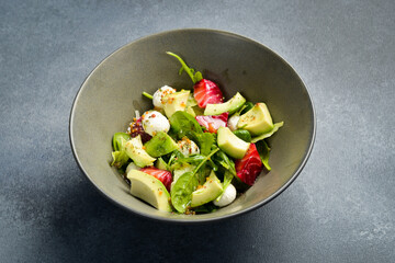 Salad with salmon, avocado, spinach and mozzarella cheese. Close up.