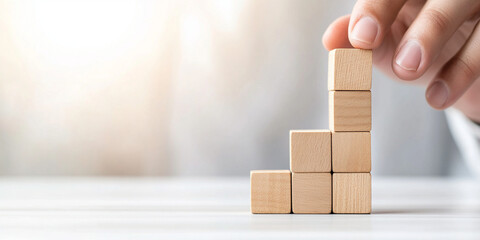 Building wooden block structure symbolizes growth and progress in business. hand carefully stacks blocks, representing strategic planning and development
