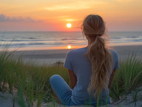 Woman Watching Sunset at Beach Sitting on Sand Dune Grass