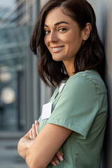 Fototapeta premium Cute female doctor standing at the wall and having a small break after work
