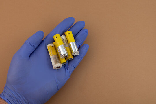 Old used alkaline batteries LR6 type or AA, close-up. Oxidized and leaked batteries, leakage of alkaline electrolyte. Concept of separate waste collection. Problems of electronic waste recycling