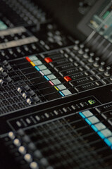 Close-Up of Professional Audio Mixing Console with Illuminated Sliders Representing Music...