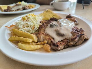 Chicken Steak with Mushroom Cream Sauce french fried and salad delicious food in Thai restuarant
