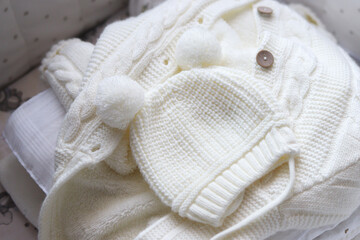 set of children's warm clothes in white. knitted sweater, overalls, hat with pompoms. clothes are soft, comfortable, suitable for the cold season. Baby care. High quality photo