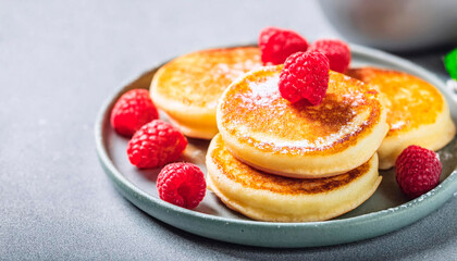 Japanese fluffy pancakes with raspberries in a gray plate, gray background. Japanese cuisine concept.